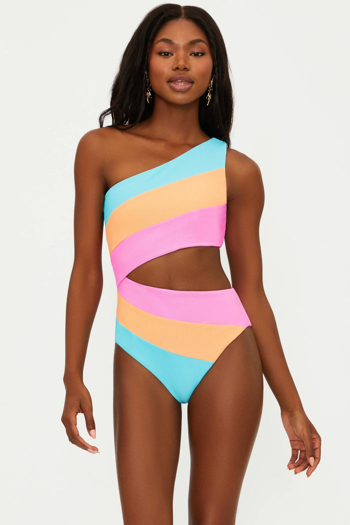 A model wearing an asymmetrical neckline, one-shoulder, colorblock patterned one-piece swimsuit in blue, orange, and pink.