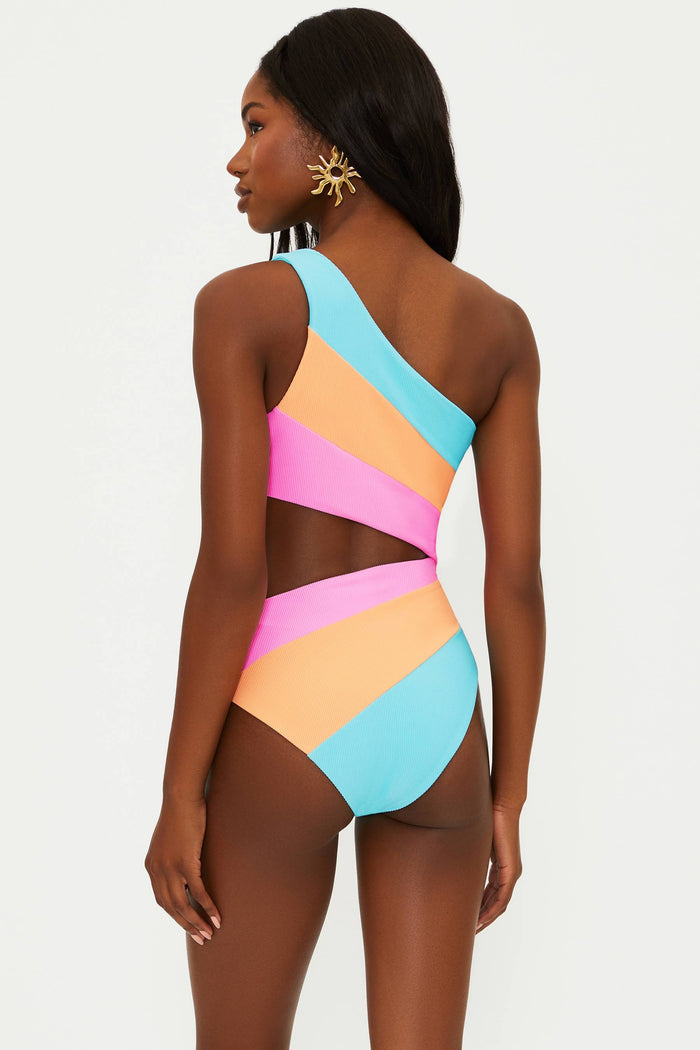 A model wearing an asymmetrical neckline, one-shoulder, colorblock patterned one-piece swimsuit in blue, orange, and pink.