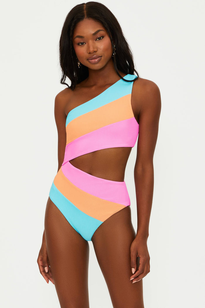 A model wearing an asymmetrical neckline, one-shoulder, colorblock patterned one-piece swimsuit in blue, orange, and pink.