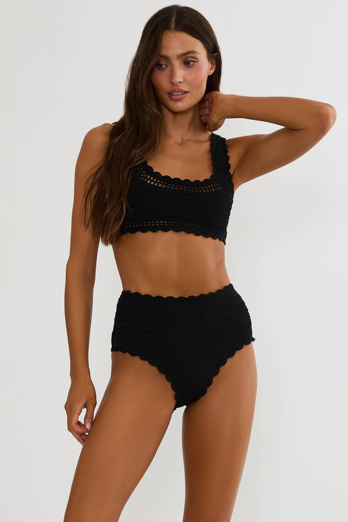 Woman wearing a black bikini set on a white background