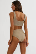 Woman wearing a beige crochet bikini set on a white background
