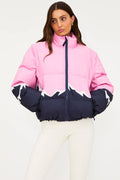 Person wearing a pink and navy puffer jacket on a white background