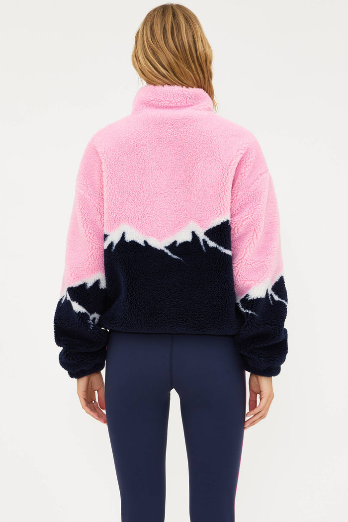 Person wearing a pink and navy fleece jacket on a white background