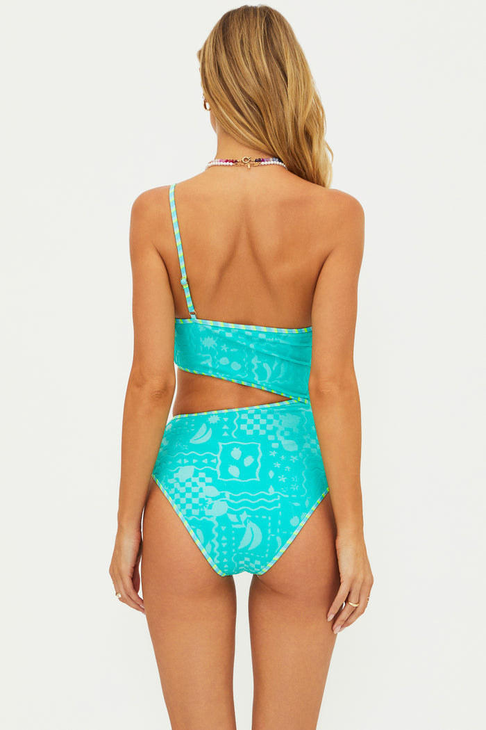 Woman wearing a turquoise patterned swimsuit on a white background