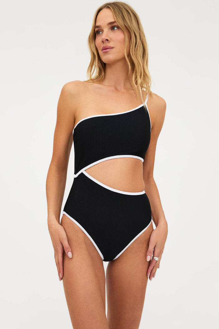 Woman wearing a black and white one-piece swimsuit on a white background