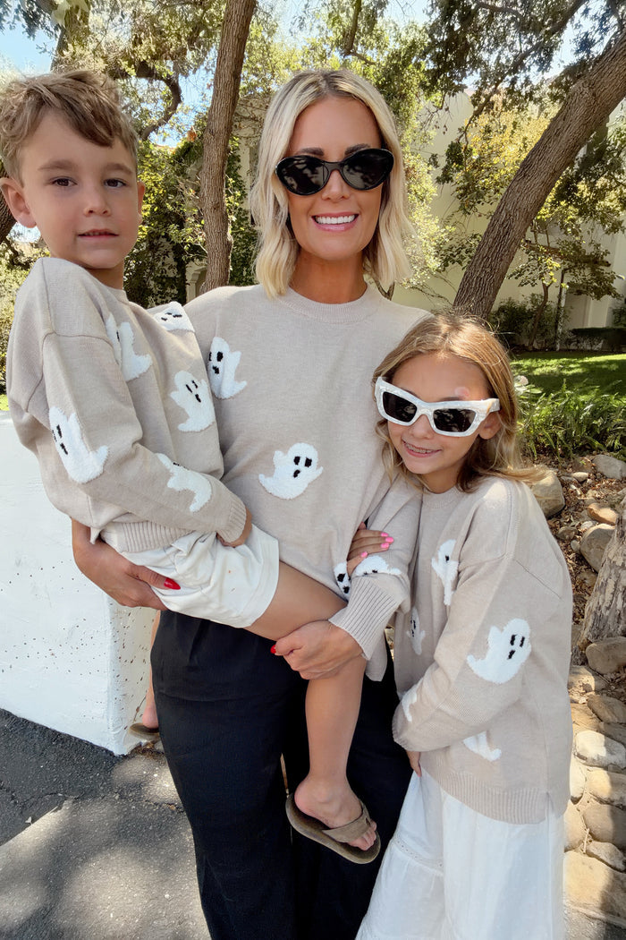 family wearing a matching oatmeal color sweater with ghosts