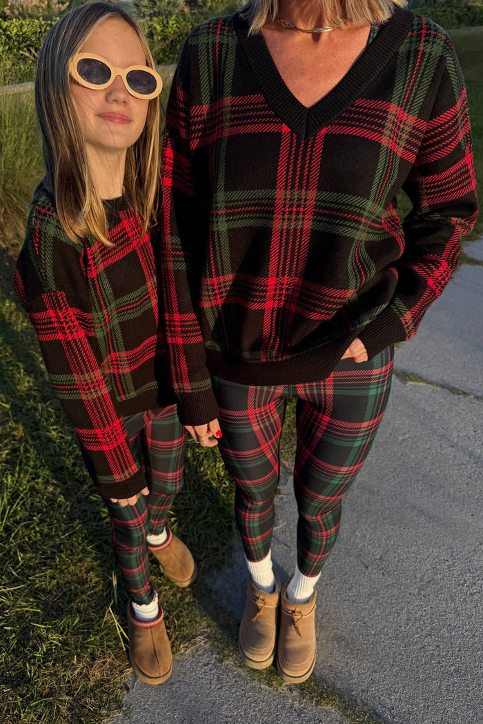 Two people wearing matching plaid outfits standing outdoors.