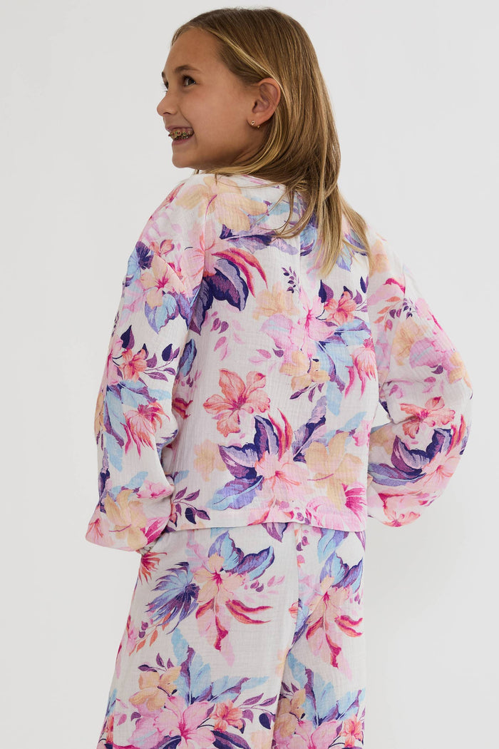 Young girl wearing a colorful floral outfit on a white background