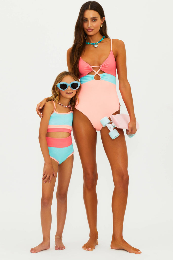 Woman and child wearing matching colorful swimsuits on a white background