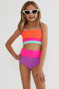 Young girl wearing a colorful two-piece swimsuit and sunglasses on a white background