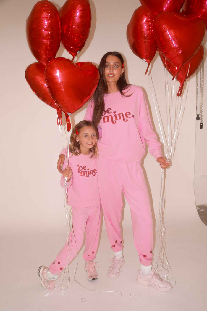 Pink sweatshirt with red glitter "be mine" text