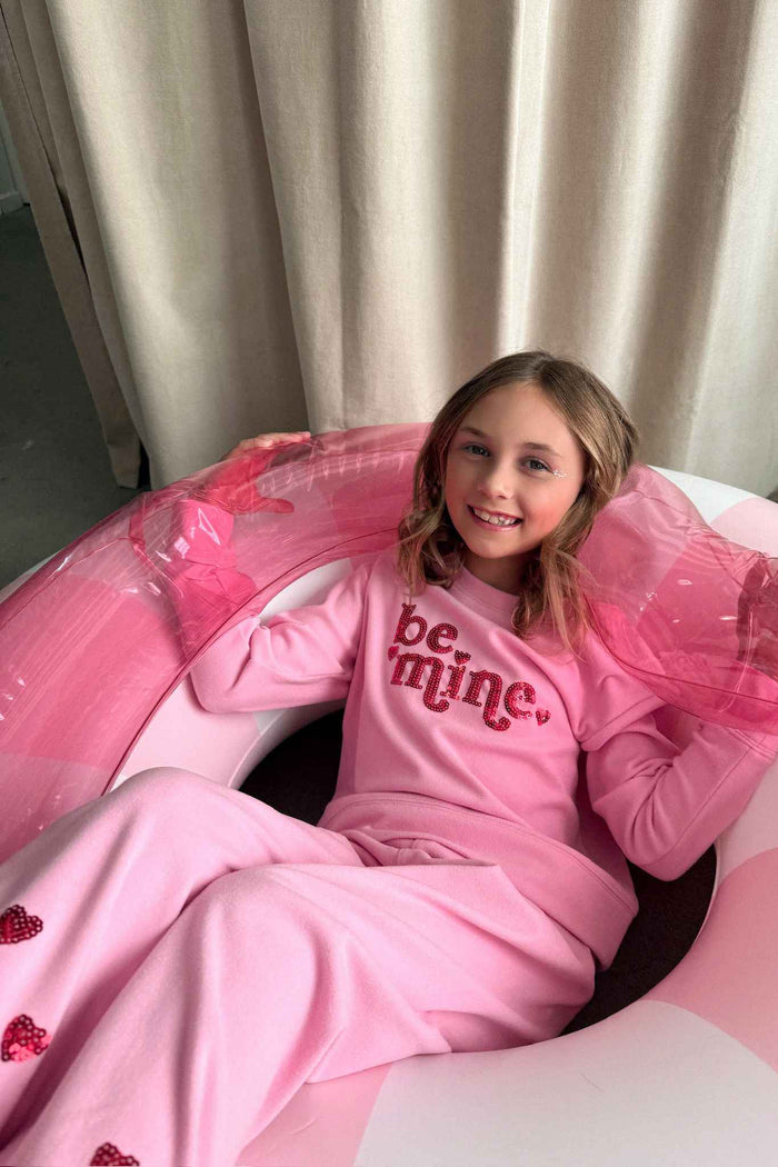 Pink sweatshirt with red glitter "be mine" text