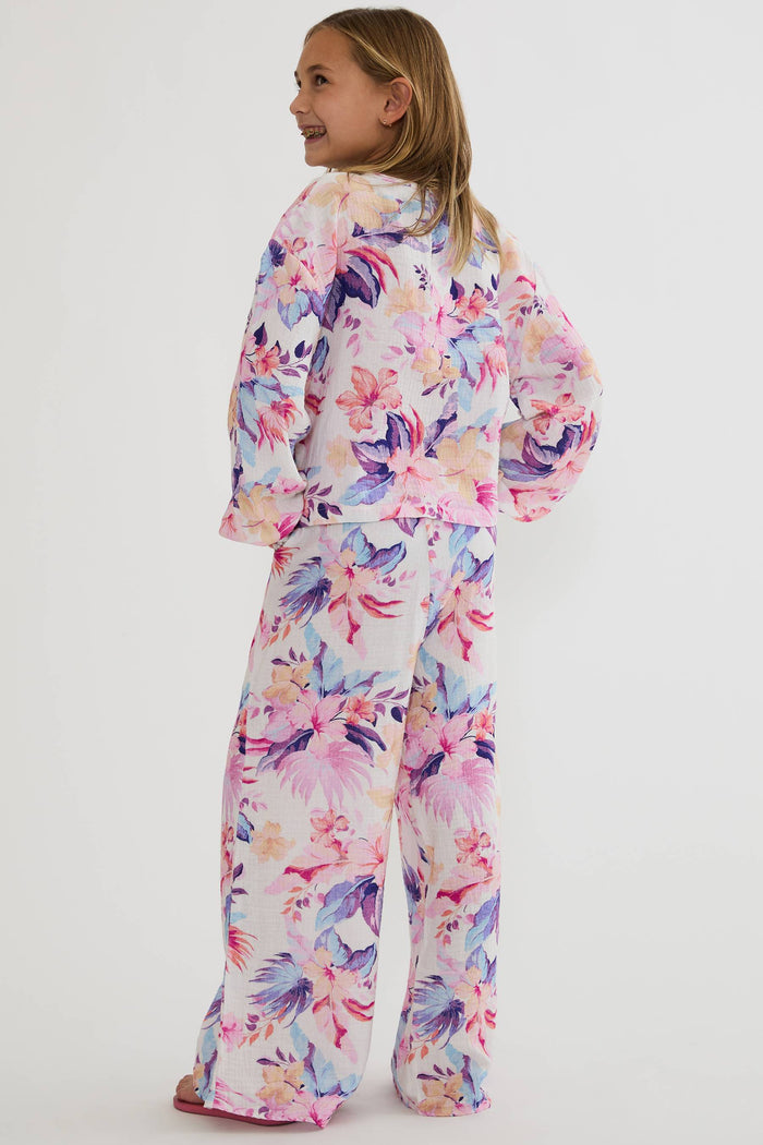 Child wearing a colorful floral pajama set on a white background