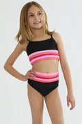 Young girl wearing a black and pink striped swimsuit on a white background