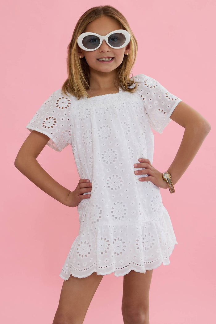 A model wearing a white short-sleeved dress with embroidered eyelet details and a square neckline.