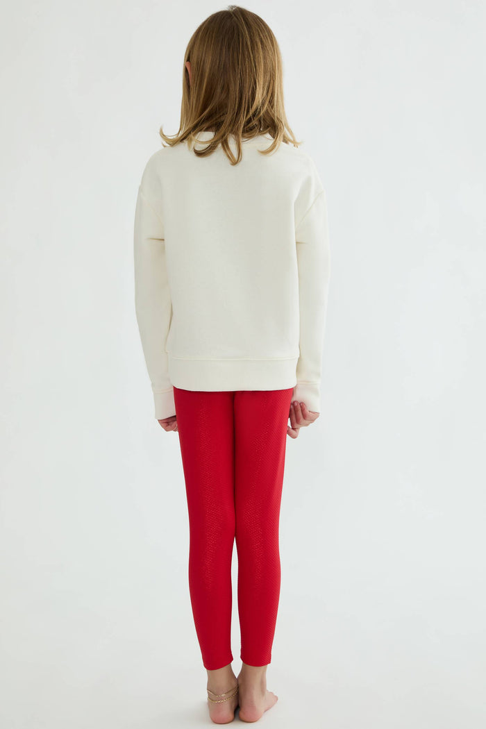 Person wearing a white sweater and red pants on a white background