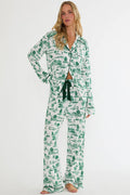 Woman wearing a green and white patterned pajama set on a white background