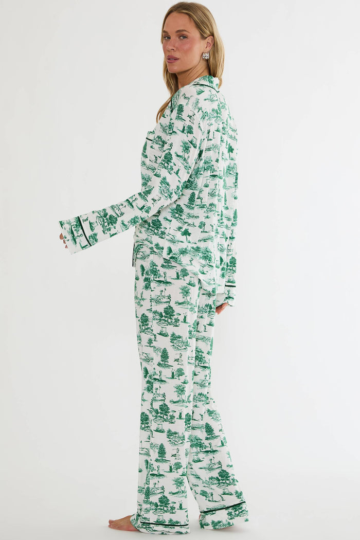 Woman wearing a green and white patterned pajama set on a white background