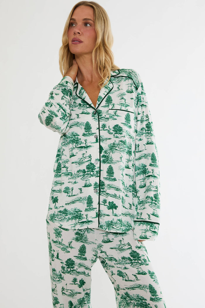 Woman wearing a green and white patterned pajama set on a white background
