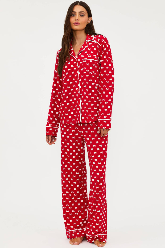Woman wearing red and white patterned pajamas on a white background