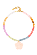 A beaded necklace with a rainbow gradient of small round beads and a central pale pink flower-shaped charm, finished with a gold clasp on a white background.