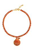 A beaded necklace featuring round terracotta orange beads and a central shell-shaped pendant with a gold-tone border and clasp, shown on a plain white background.