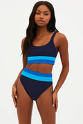 A model wearing a navy and blue colorblock sports bikini top with a scoop neckline and thick shoulder straps.