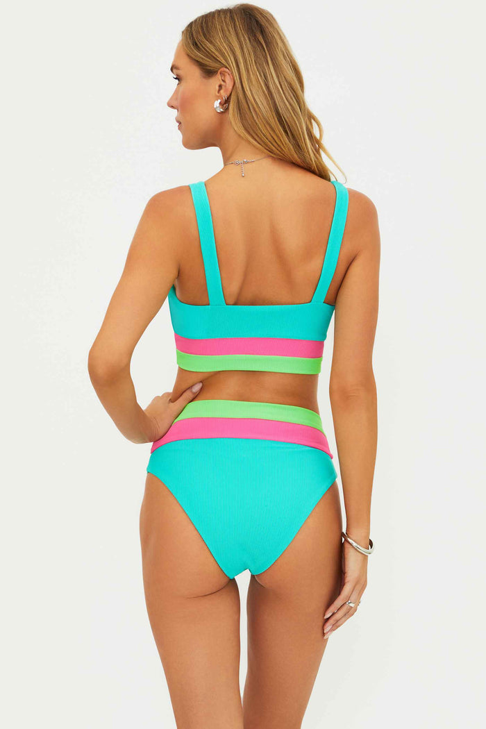 Woman wearing a colorful swimsuit with a white background
