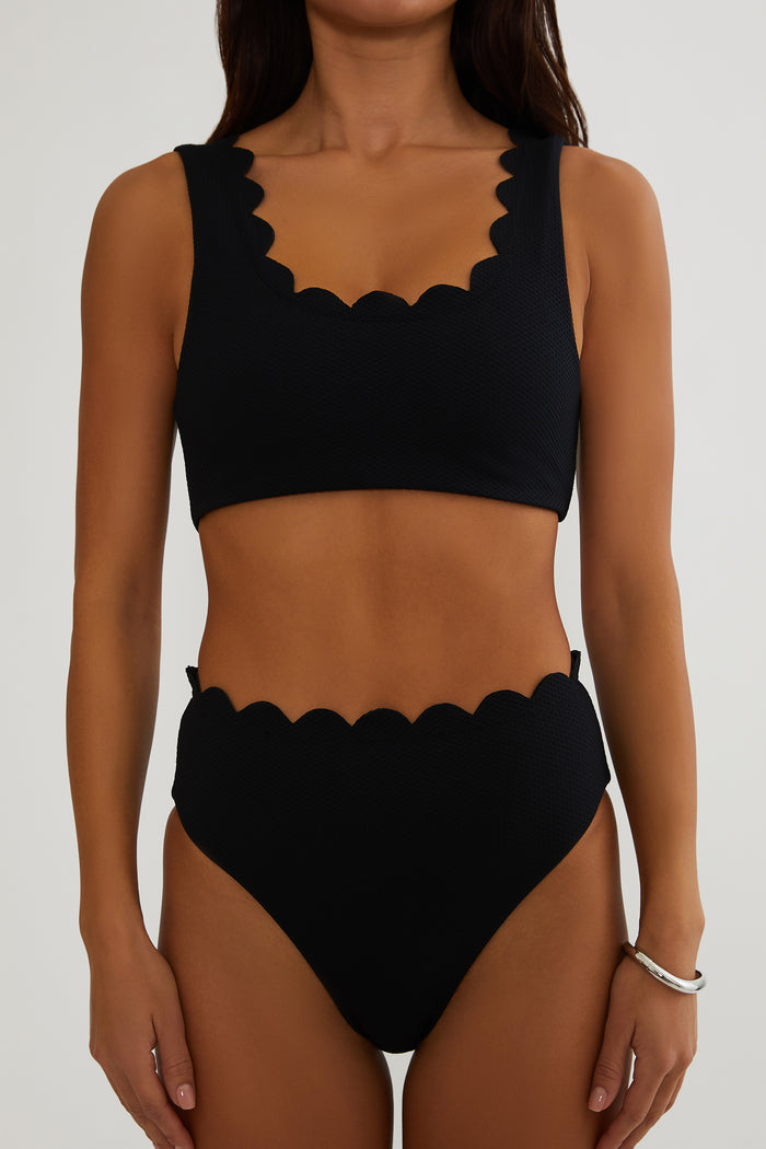 Black bikini set with scalloped edges on a white background
