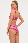 Woman wearing a pink floral bikini set on a white background