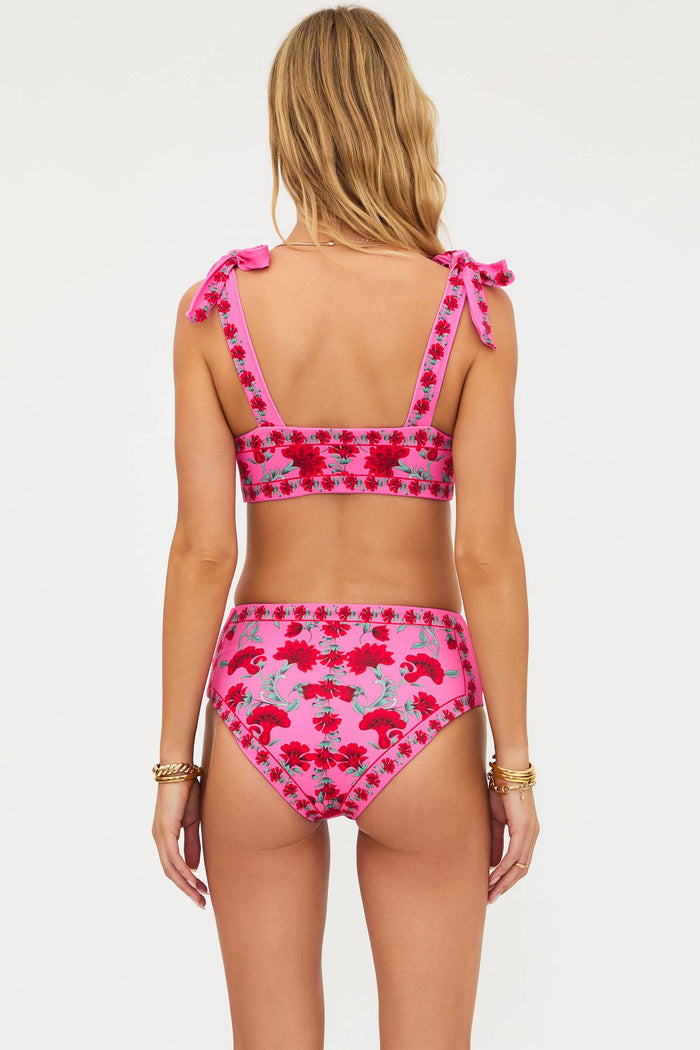Woman wearing a pink floral bikini set on a white background
