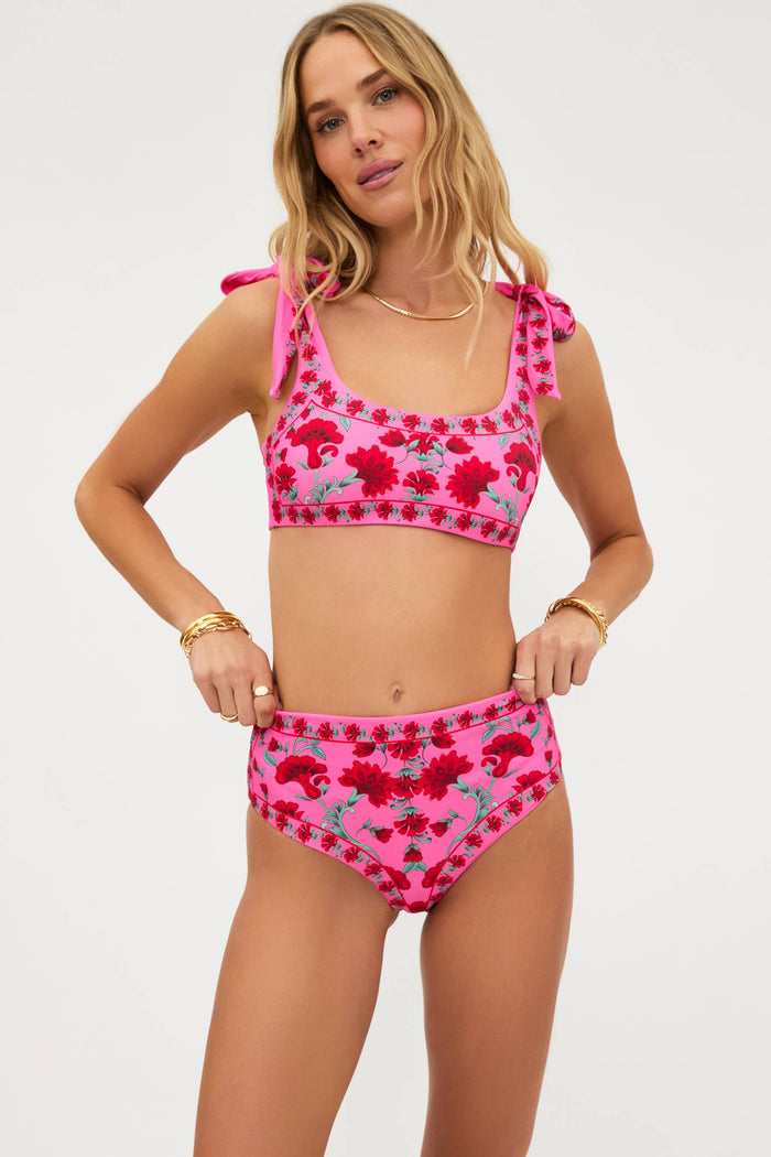 Woman wearing a pink floral bikini set on a white background