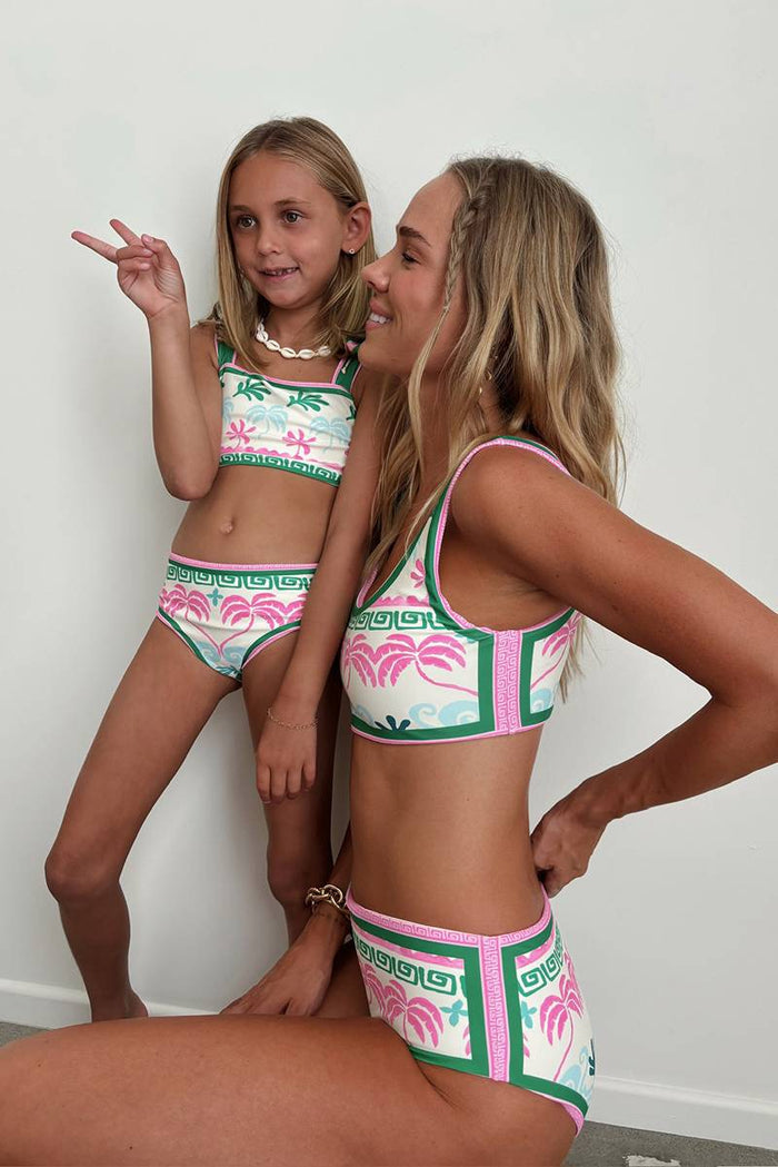 A person wearing a tropical palm floral print swim bottom.