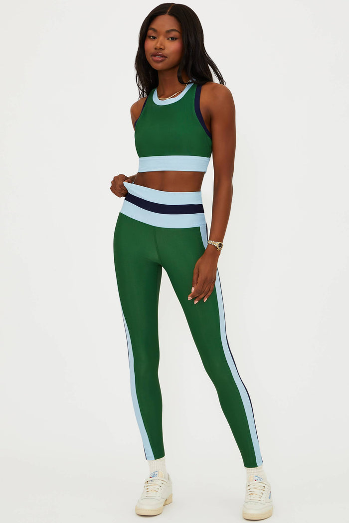 Woman wearing a green and white athletic outfit on a white background