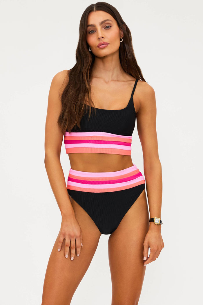 Woman wearing a black and pink striped bikini on a white background