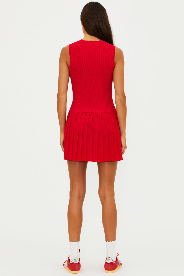 Woman wearing a red dress with white socks and red sneakers on a white background