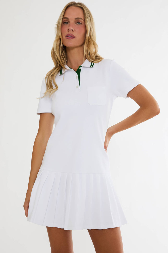 Woman wearing a white dress with green accents on a plain background