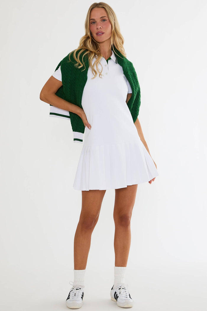 Woman wearing a white dress with a green cardigan on a white background