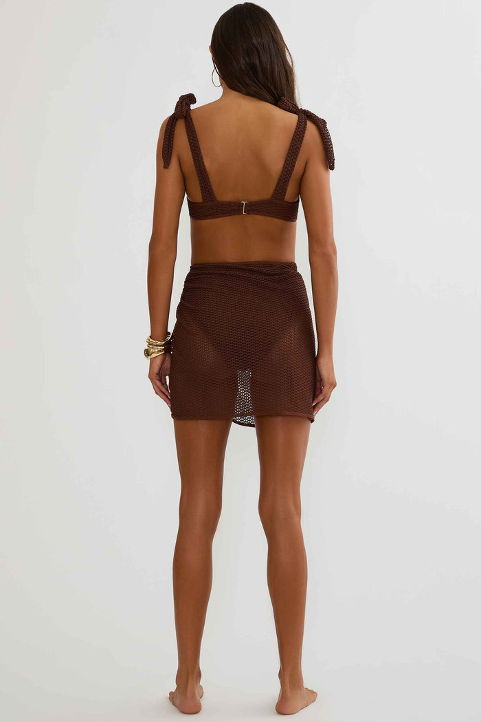 Woman wearing a brown bikini set on a white background