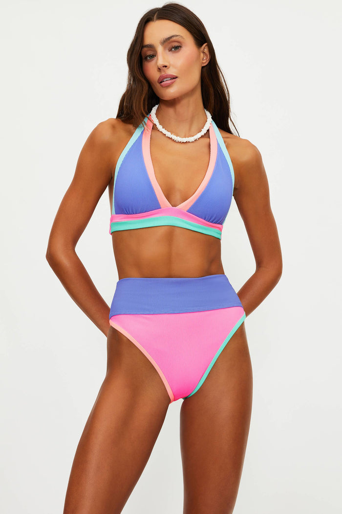 Woman wearing a colorful bikini set on a plain background
