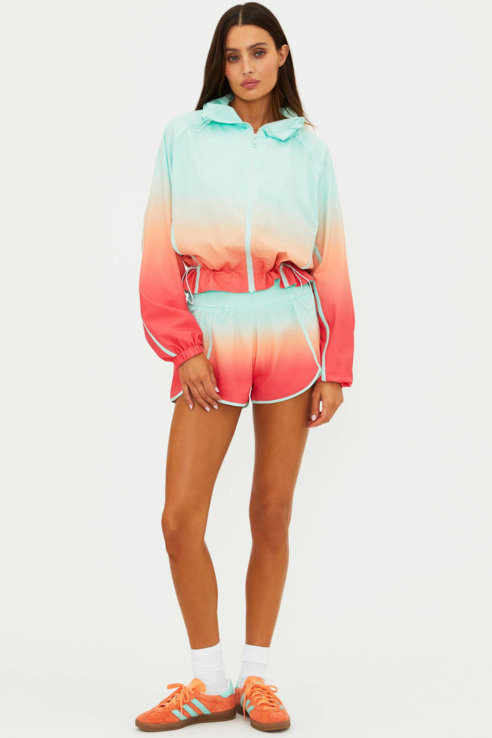 Woman wearing a colorful ombre hoodie and shorts set on a white background