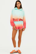 Woman wearing a colorful ombre hoodie and shorts set on a white background