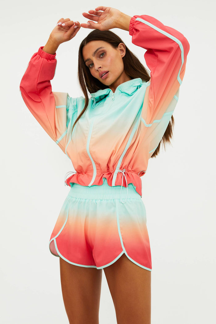 Woman wearing a colorful ombre outfit with a jacket and shorts on a white background