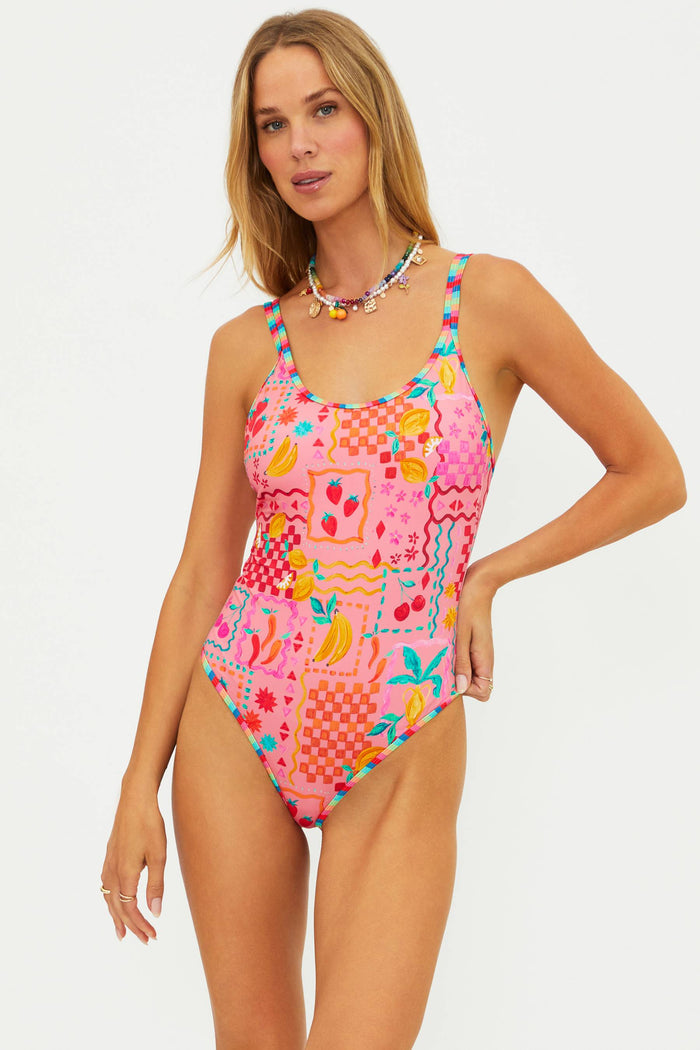 Woman wearing a colorful patterned swimsuit on a white background