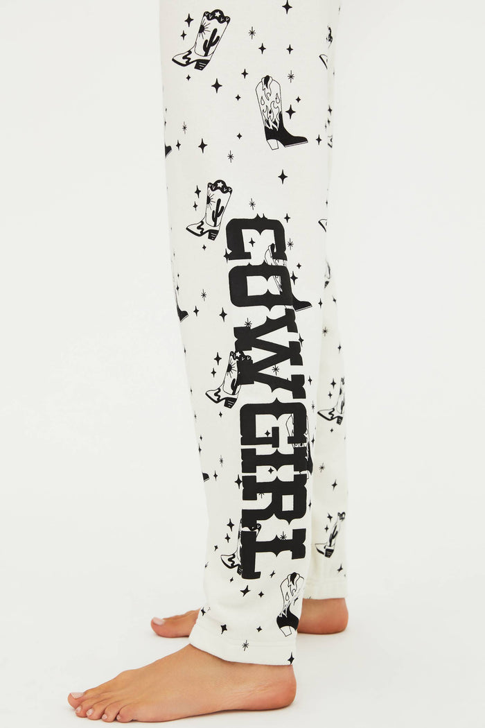 White pajama pants with black 'COWGIRL' text and star patterns on a white background
