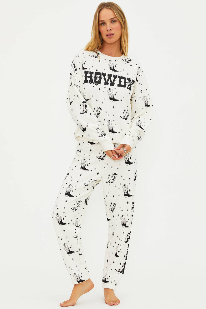 Woman wearing a white pajama set with black animal prints and 'HOWDY' text on a white background