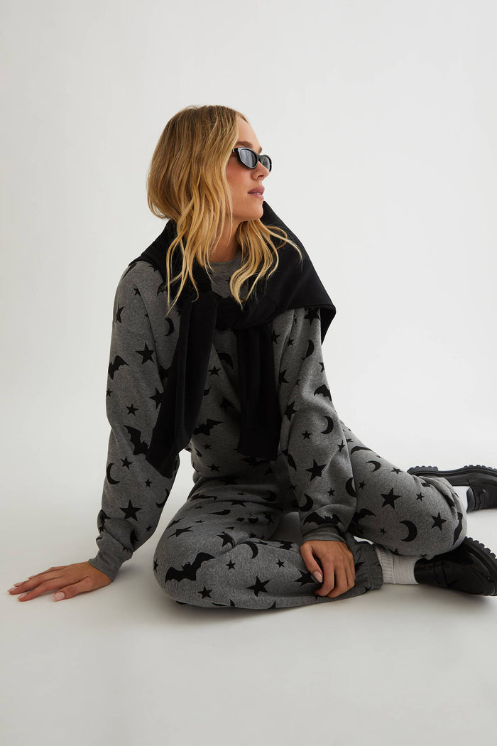 Grey sweatpants with black stars, moon, and bats.