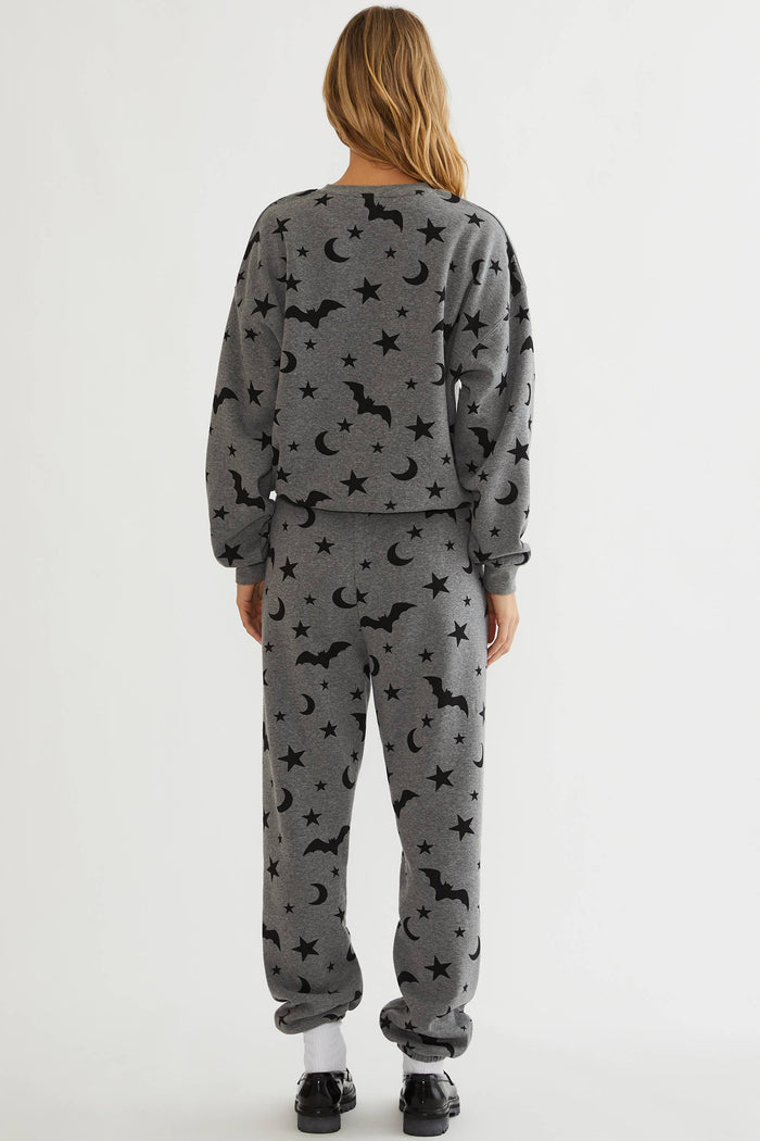Grey sweatpants with black stars, moon, and bats.