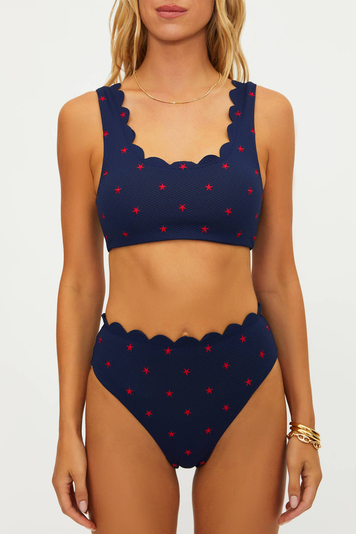 Navy blue bikini with red star pattern on a white background