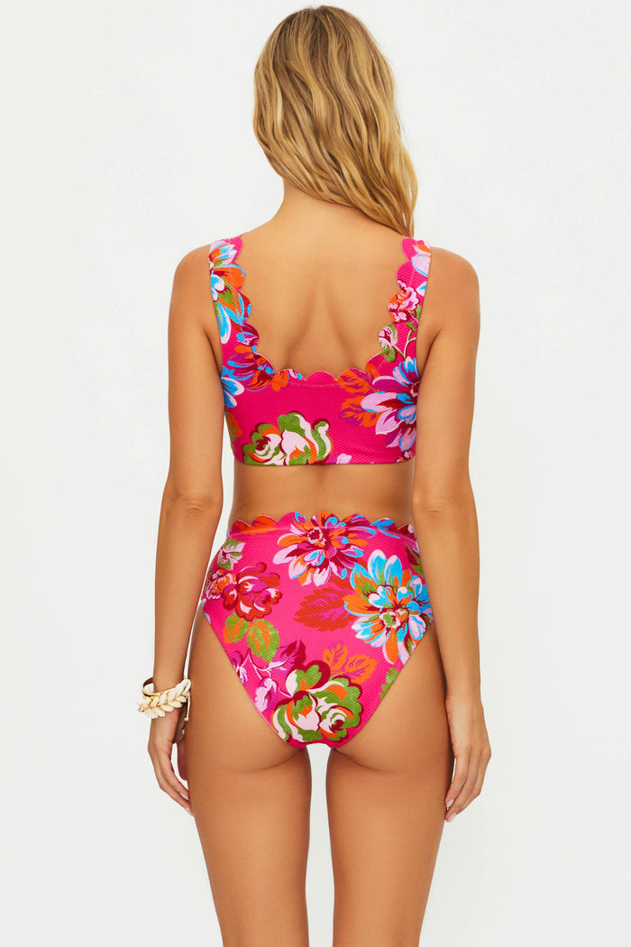 Woman wearing a colorful floral bikini set on a white background